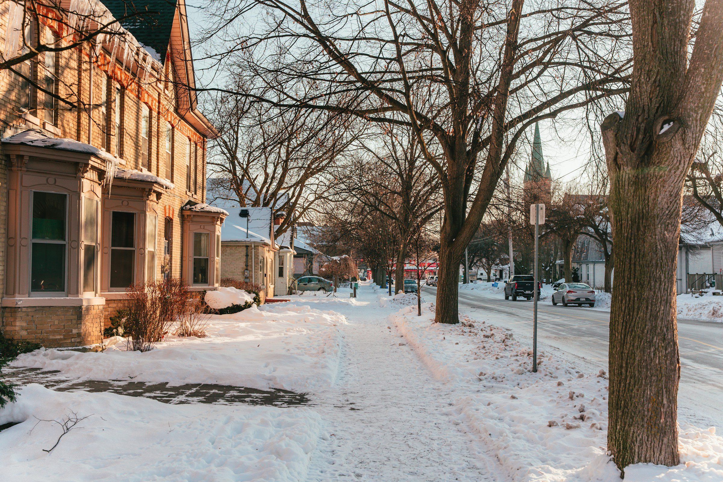 Cleared front walk and sidewalk on a snowy residential street